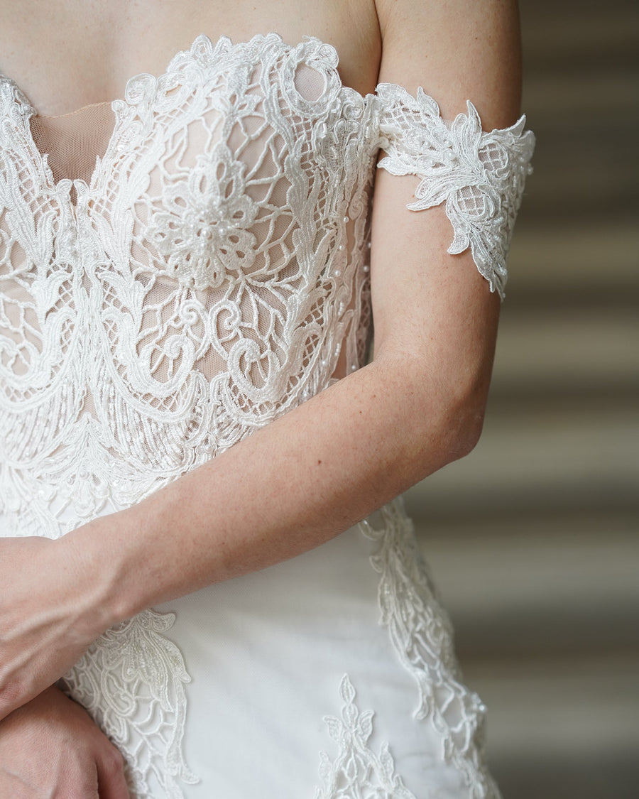Gros plan sur le bustier en dentelle guipure de la robe de mariée SERELLE, appliques florales et perles cousues à la main à l’atelier boutique AM LUX COUTURE de Lyon