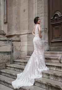 Robe de mariée sirène LUCILLE en dentelle brodée à traîne, vue de trois quarts sur un escalier de pierre à Lyon, AM LUX COUTURE