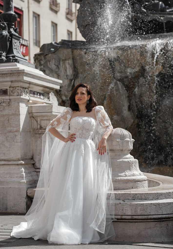 Robe de mariée princesse à Lyon Manches cape et détails floraux